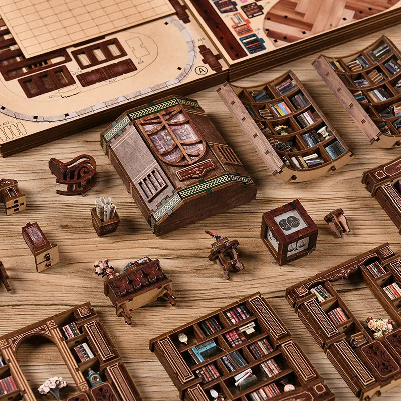 Dreamy Book Hall DIY miniature house parts layout overhead flatlay – all laser-cut wooden structural sheets, curved balcony panels, UV-printed bookshelf sections, miniature furniture pieces and accessories spread out on a wooden surface before assembly