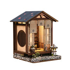 【Moss-Lantern Harmony Garden】 DIY miniature house fully assembled, showing herringbone roof, dark brown wood grain eaves, openable shoji door, and bamboo blind with family crest on lintel