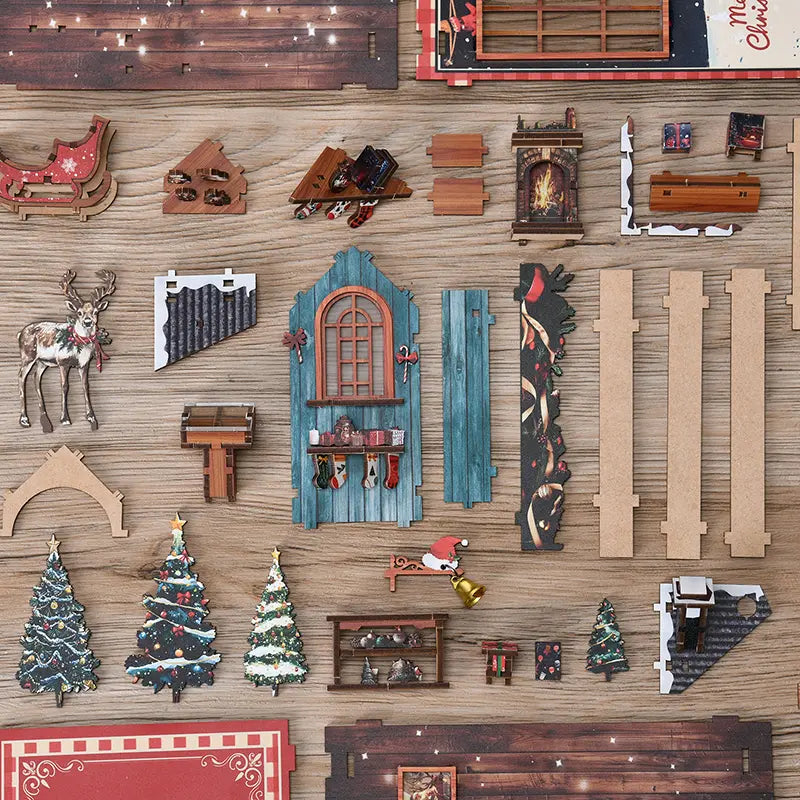 【Snow Realm Wei Pavilion】 DIY parts top-down display: includes multiple printed wooden sheets, miniature reindeer, mini Christmas trees, blue wooden cottage walls, sleigh, fireplace, golden bells, and other rich Christmas elements, spread across a wooden desk