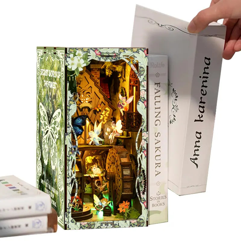【Secret World of the Forest】 can be held in one adult hand, size comparison with a hand and the book Anna Karenina, intuitively showing the book nook's height of approx. 23cm, perfect for shelf or desk placement