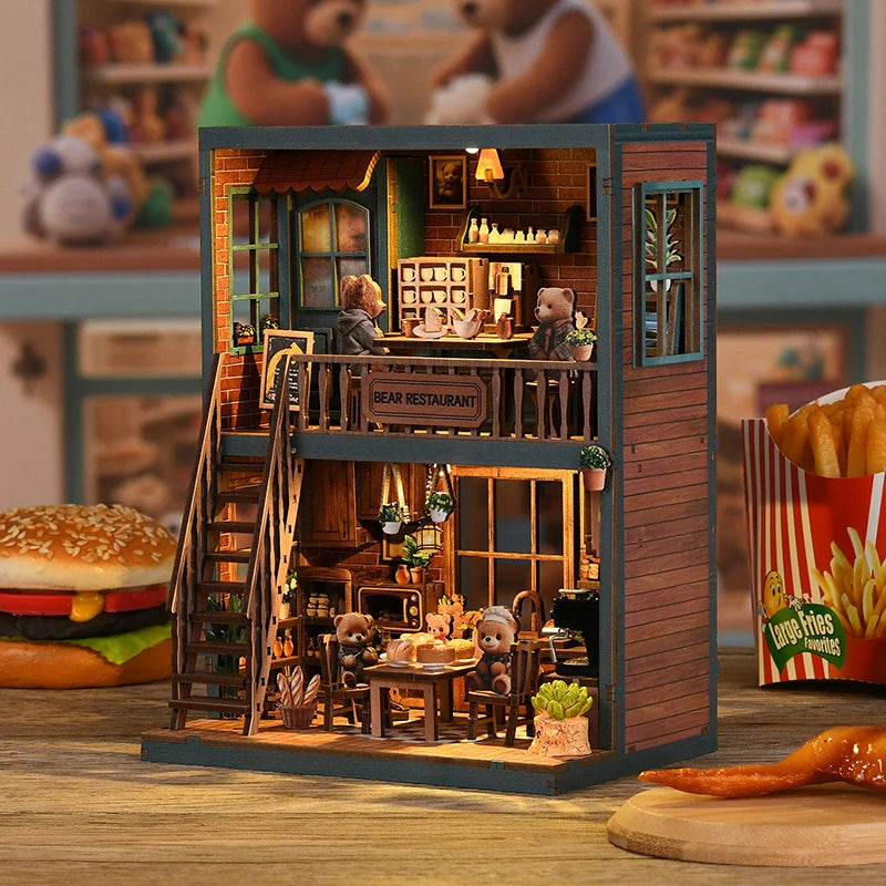 Bear Restaurant DIY miniature house side angle – exposed brick wall texture, wooden balcony railing with Bear Restaurant sign, ground floor interior with hanging plants, vintage radio and warm amber lighting

