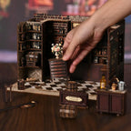 Corner Tavern DIY miniature assembly process – hands installing checkered floor tiles into wooden base frame, step-by-step craft kit for Victorian pub miniature diorama, ages 14 and up
